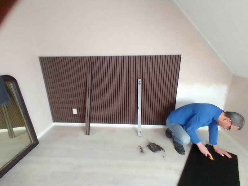 Montage van een houten lamellenwand op een zolderkamer